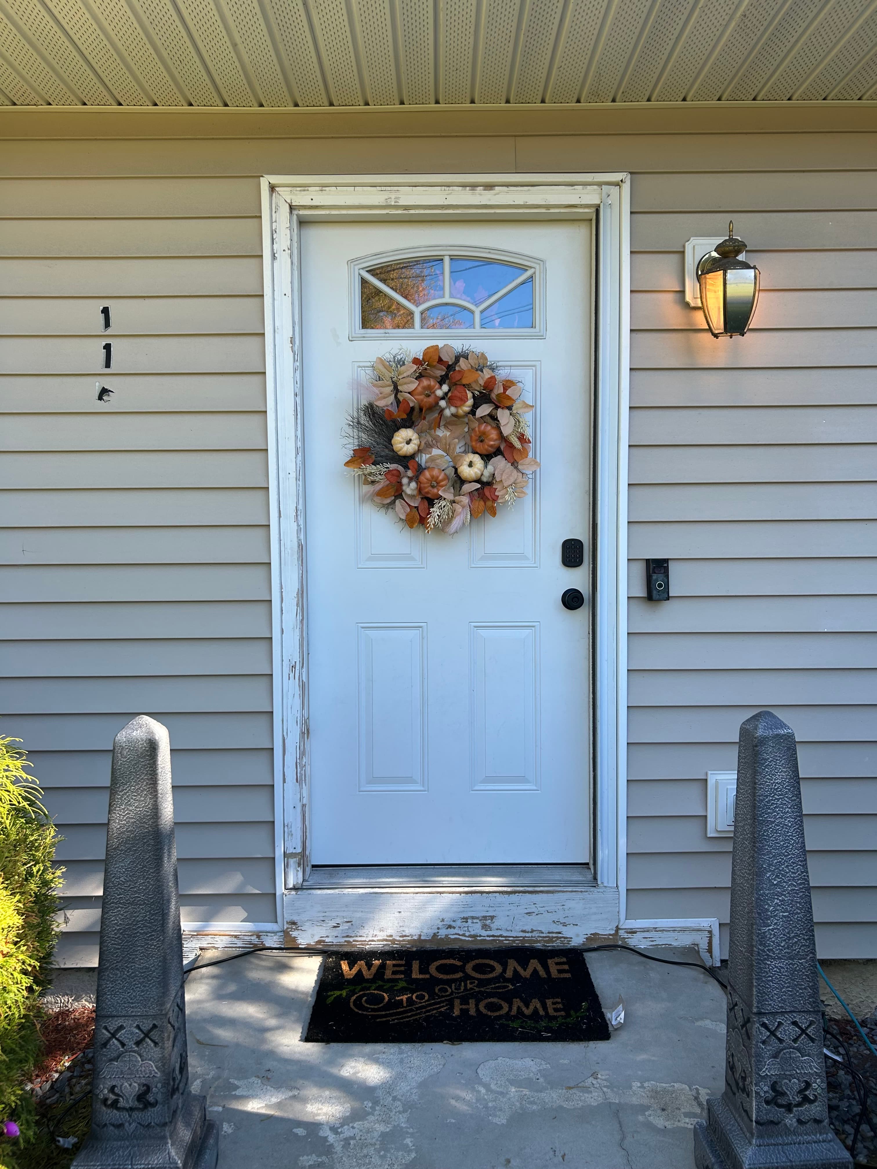White entry door with a fall wreath and side window