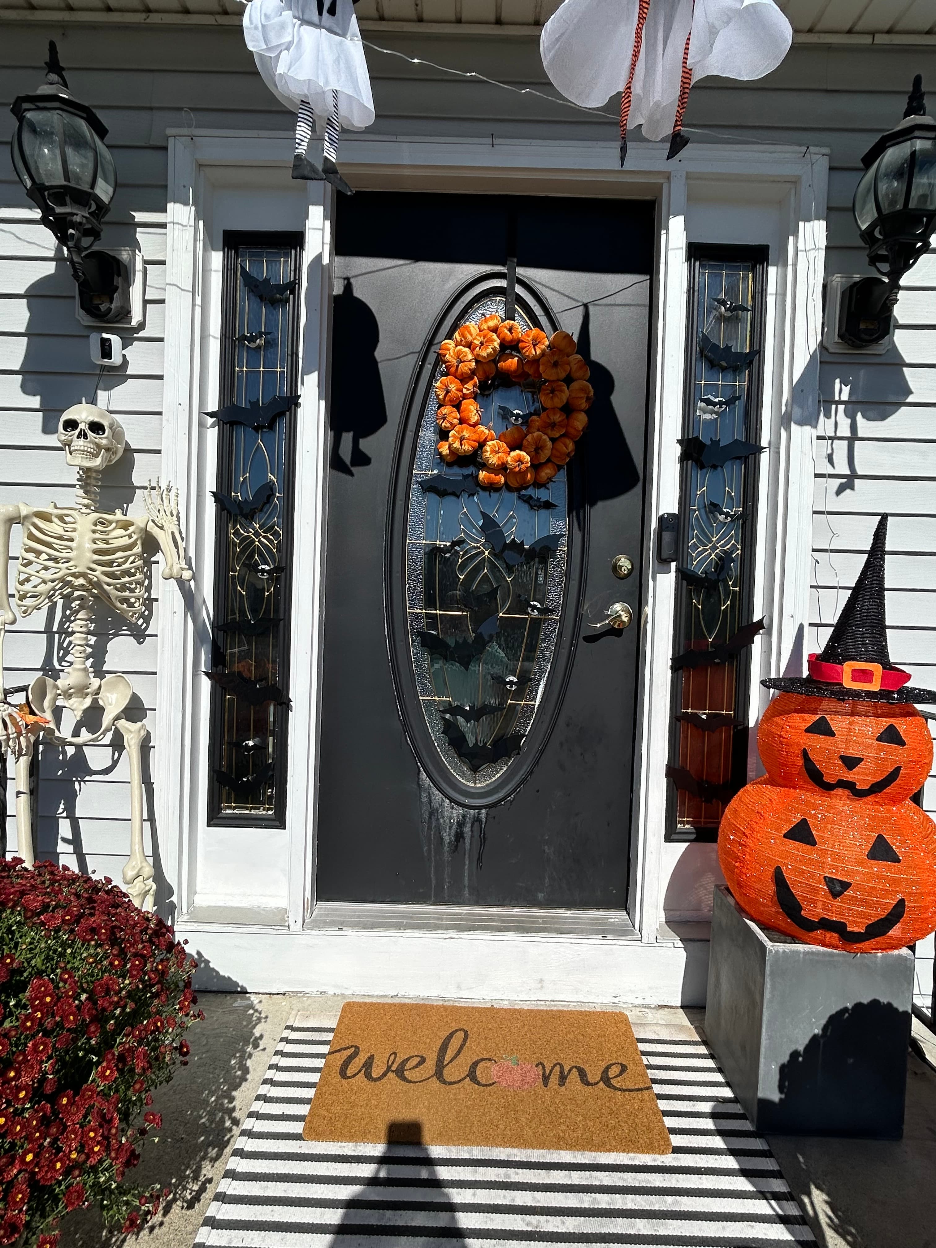 Black entry door with oval glass panel and sidelights